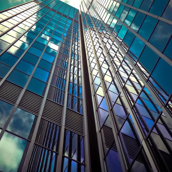 clouds reflecting on skyscraper glass windows 